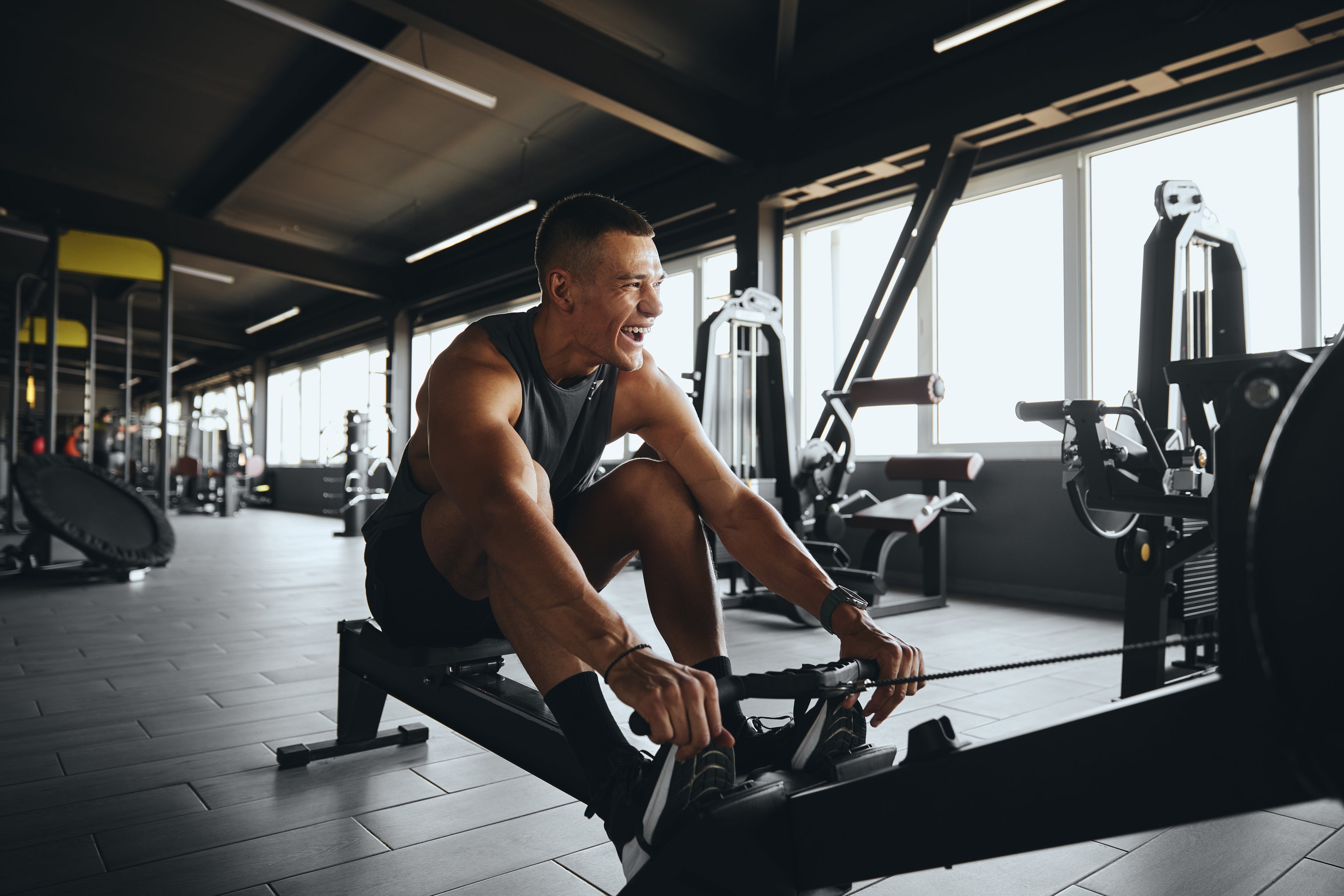 Man using a rowing machine in a gym setting