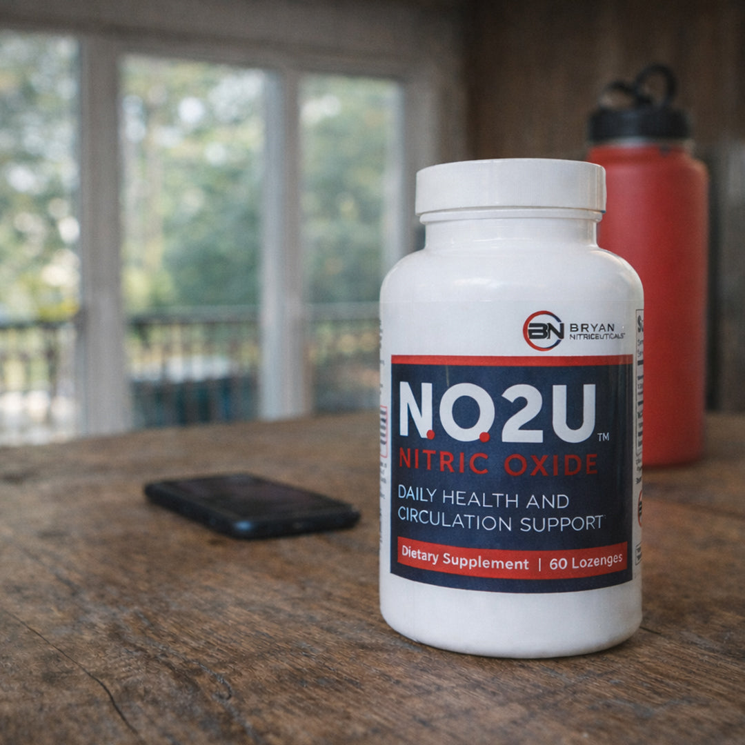 Bottle of N.O.2U Nitric Oxide supplement on a wooden surface with a blurred background