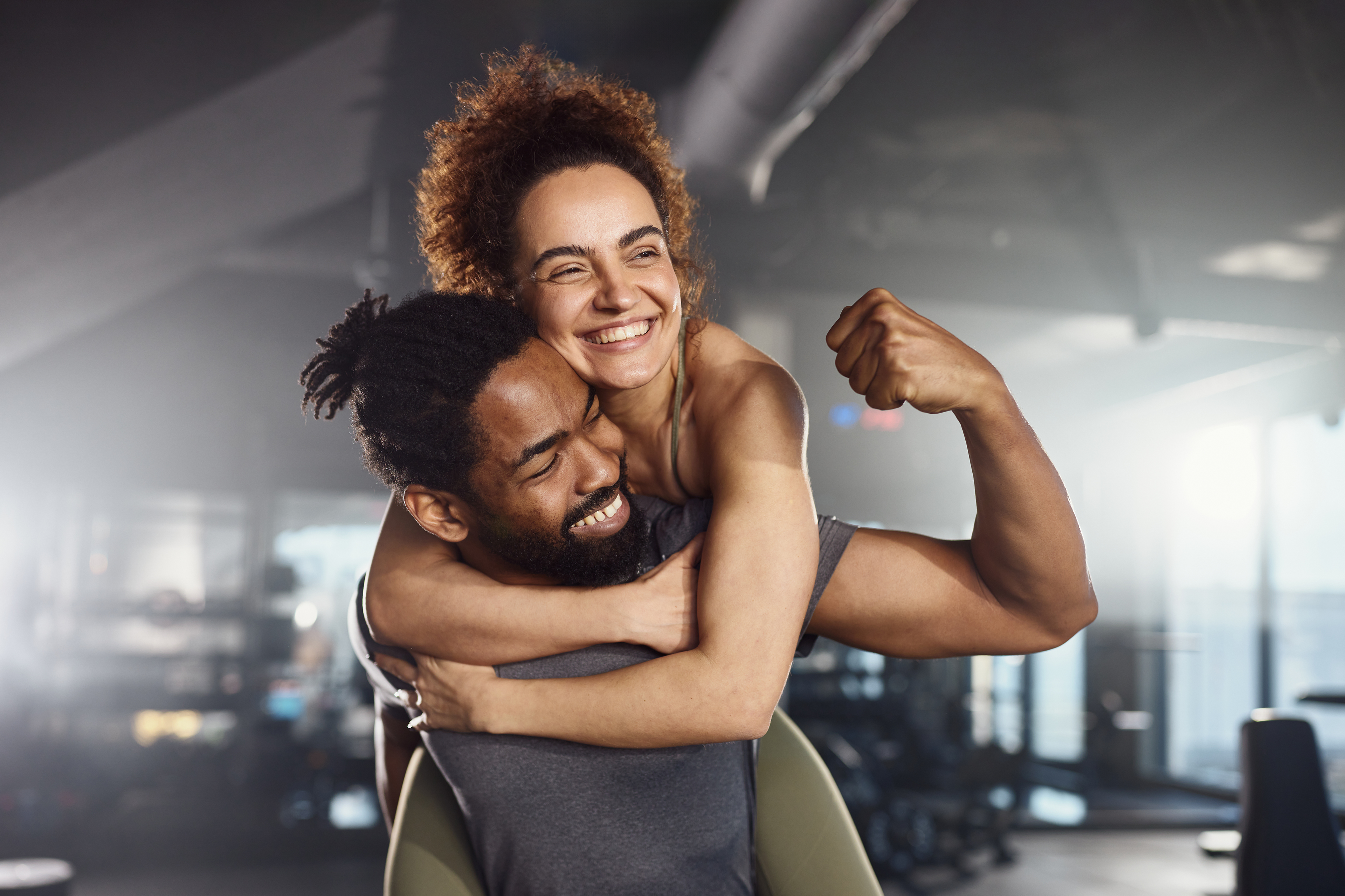 Two people holding NOZU and NO BEETZ products in a gym setting