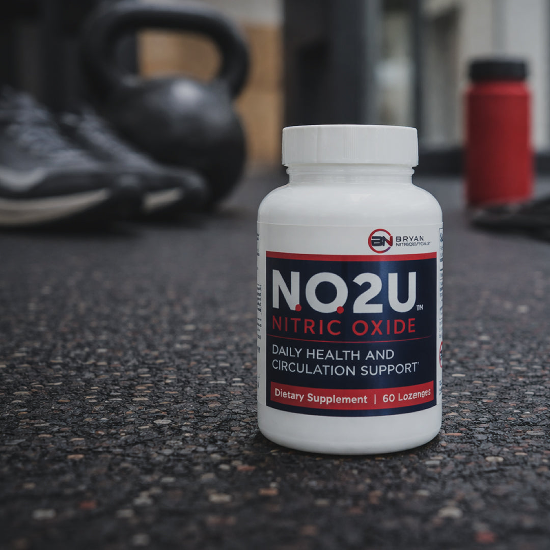 Nitric oxide supplement bottle on gym floor with black weight and red water bottle in background