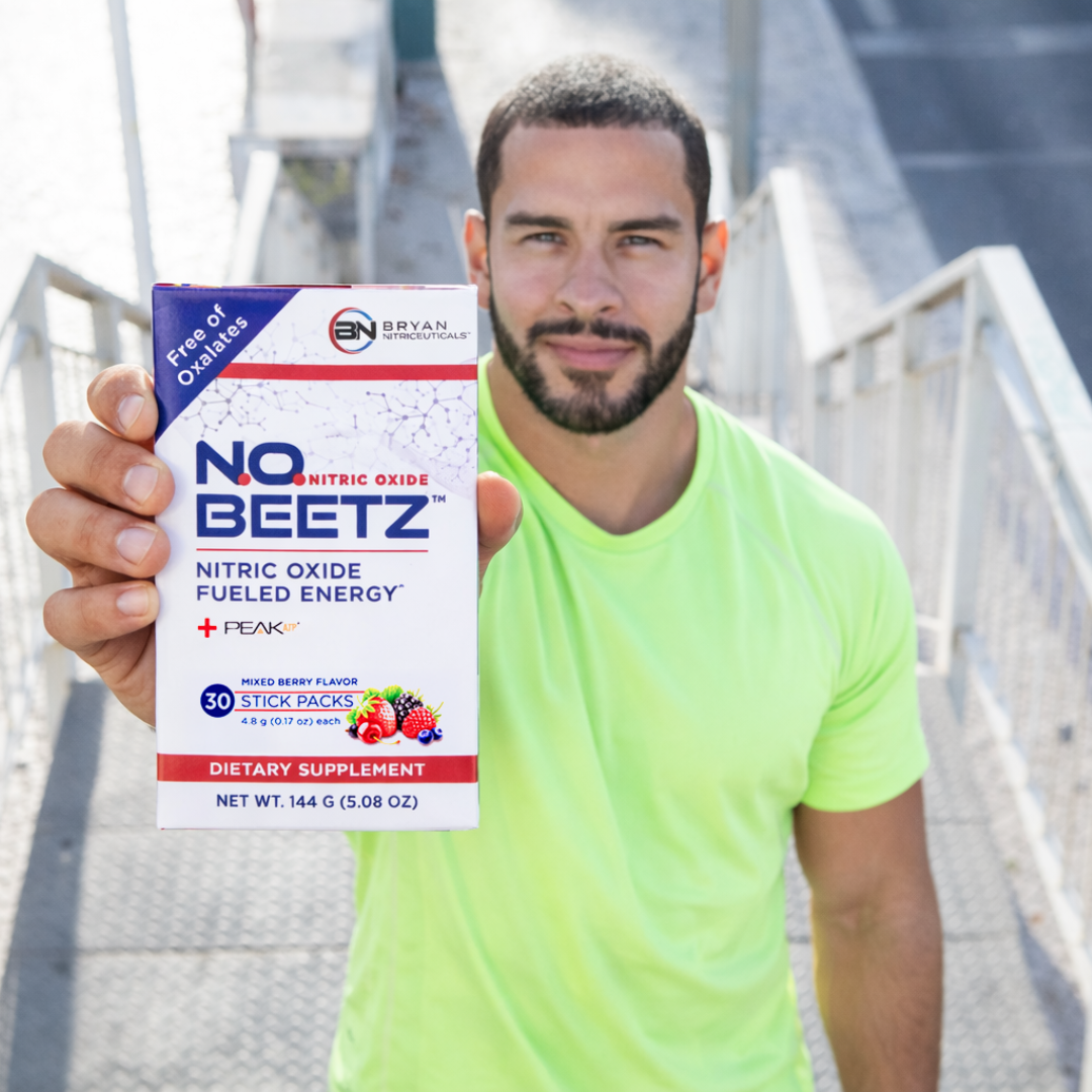 Man holding a box of NO BEETZ dietary supplement outdoors.