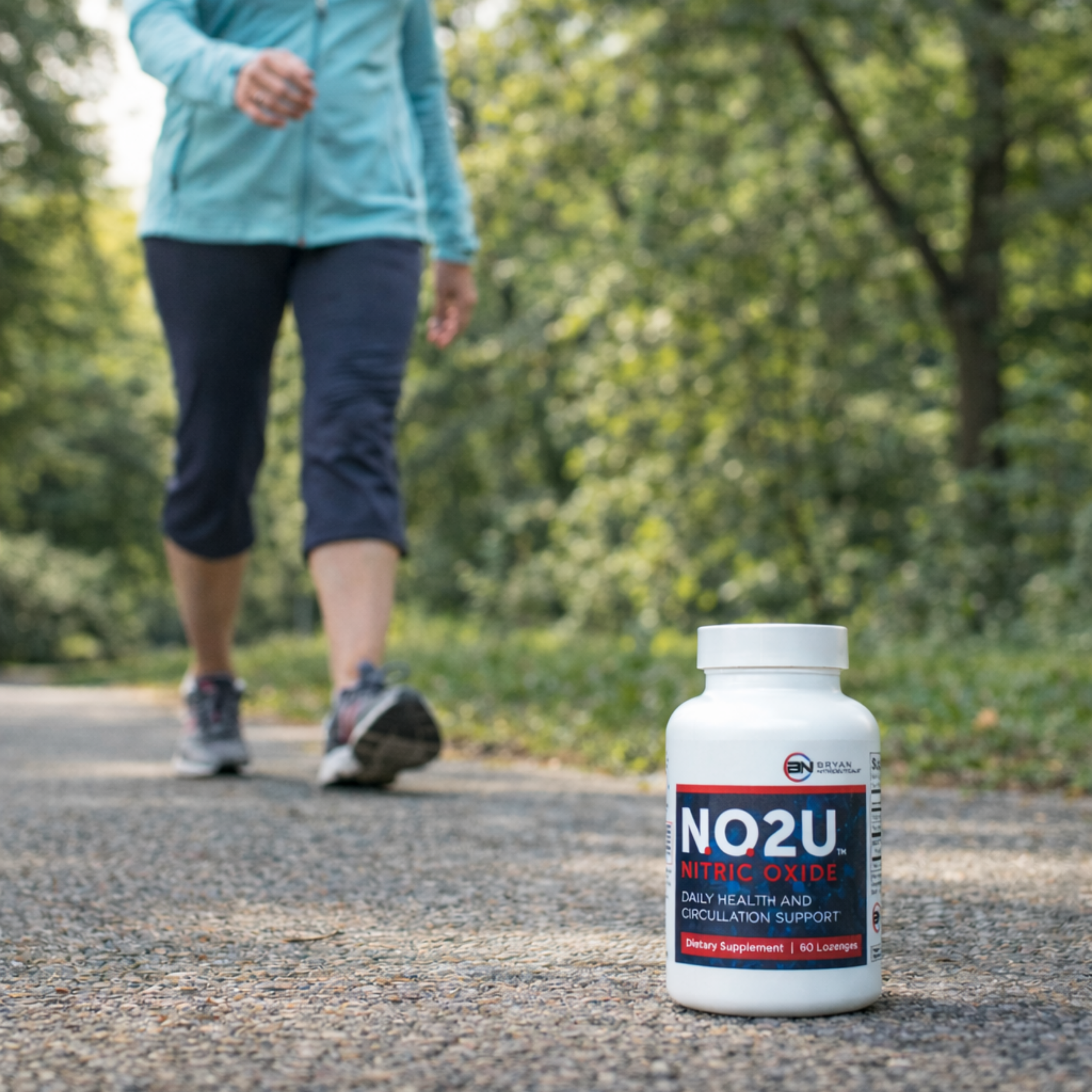 NO2U nitric oxide supplement bottle on a path with a person walking in the background