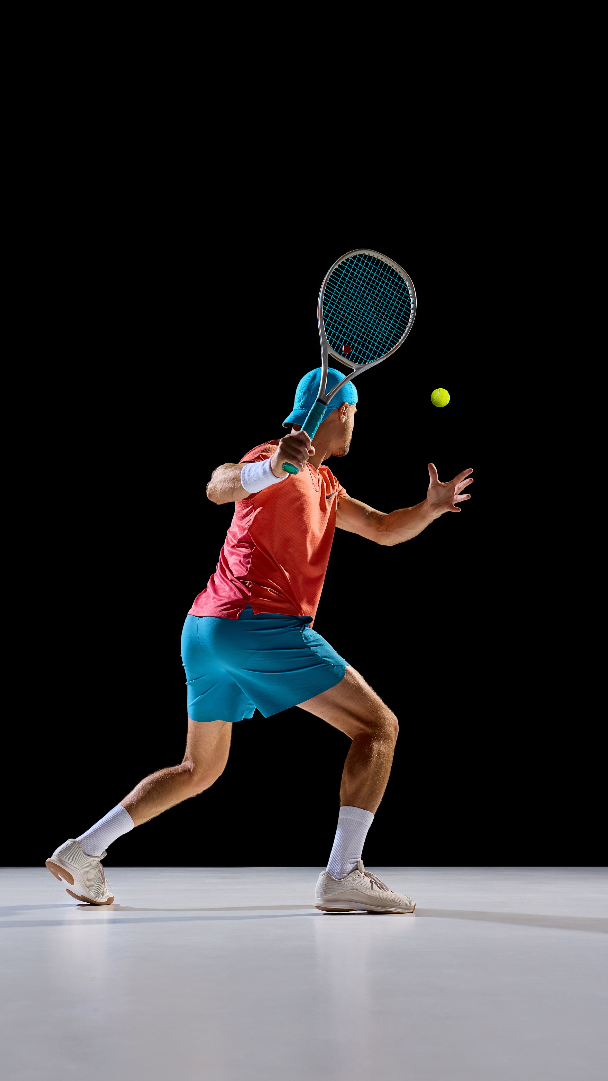 Tennis player in action on a black background